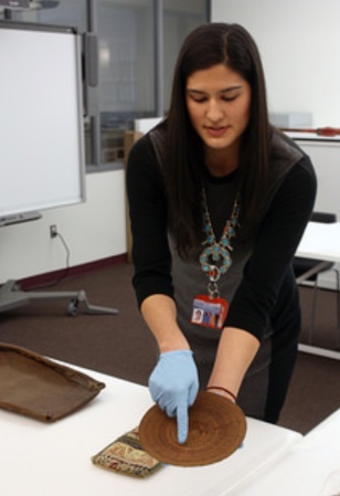 Stephanie Mach at the Penn Museum holding a Tlingit basket tray
