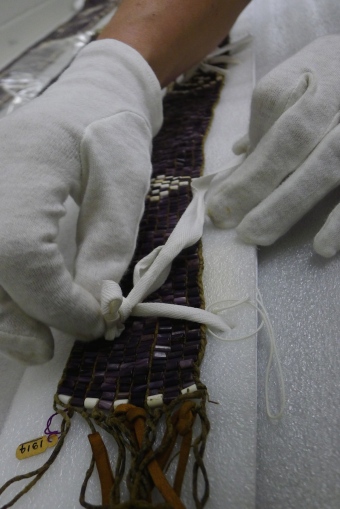 Cotton gloves, cotton twill tape, and white  polyethylene board used to store and handle wampum. McCord Museum, Montreal, Canada. Photo by Stephanie Mach.